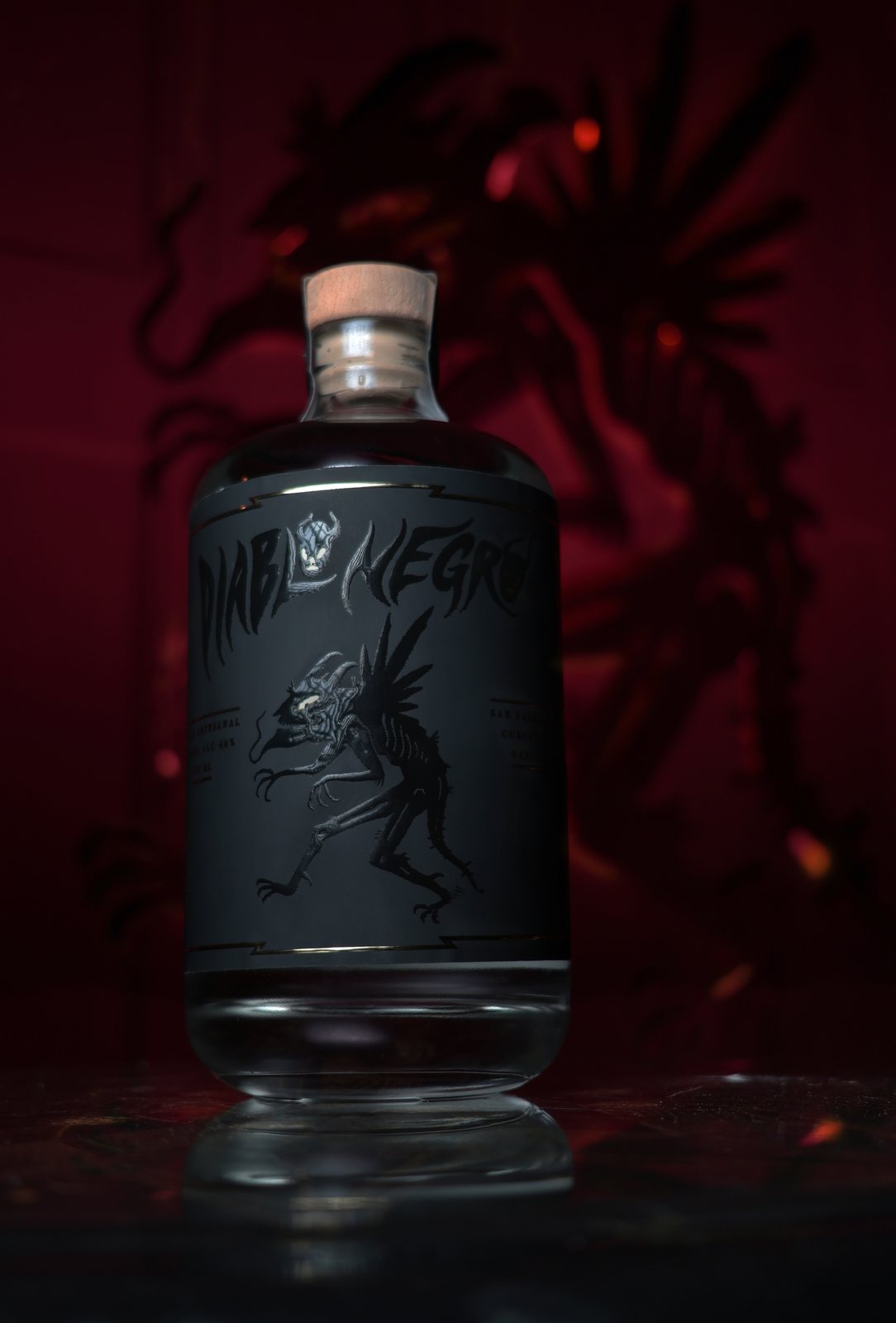Botella de Mezcal Diablo Negro frente a la sombra roja del diablo
